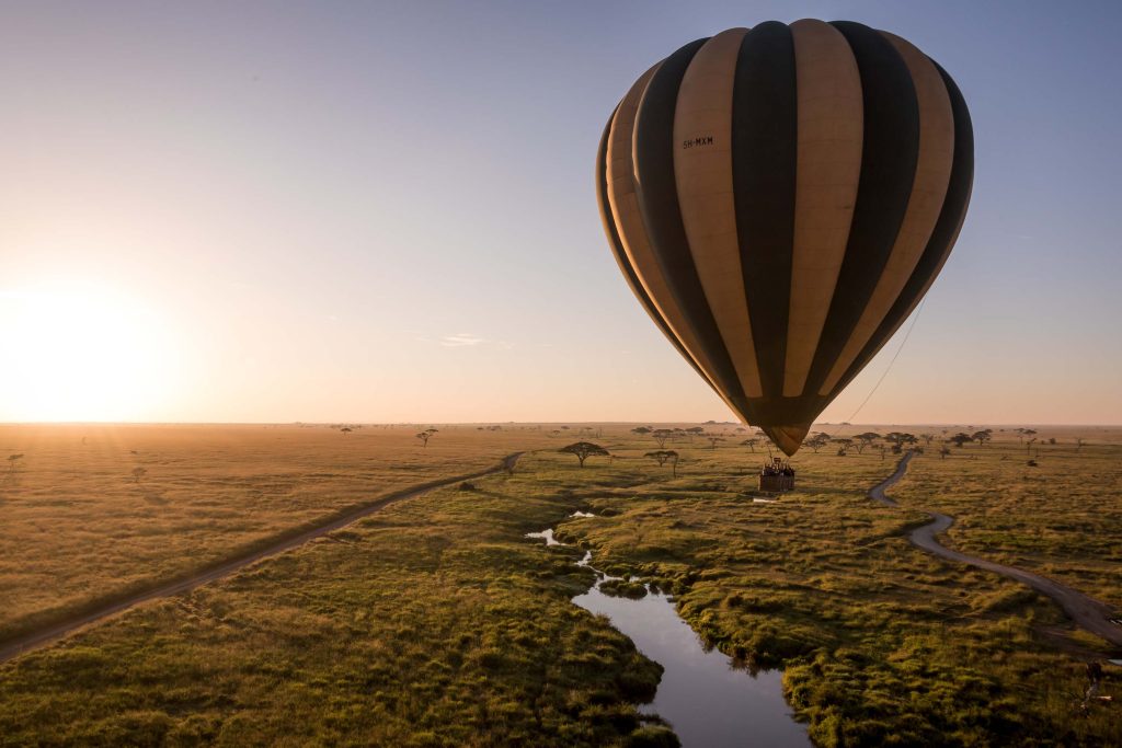 Hot-air balloon drifting over the Serengeti at sunrise